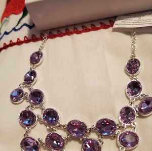Lavender colored necklace with silvertone chain.